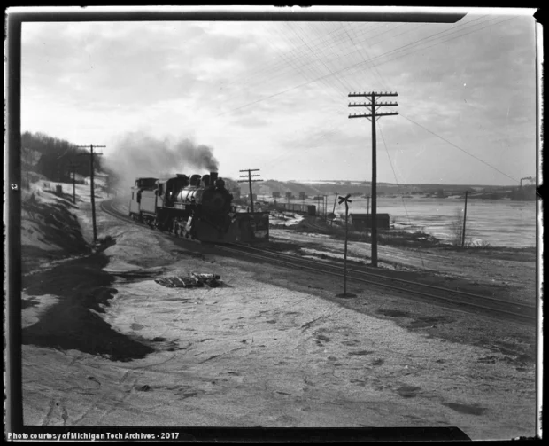 Train with snow plow on the front moving down some snowy tracks