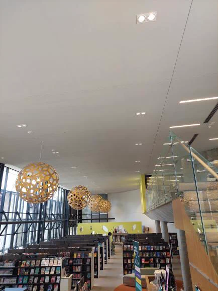 A view of library shelves with books waiting to be borrowed. A bamboo light above the library space.