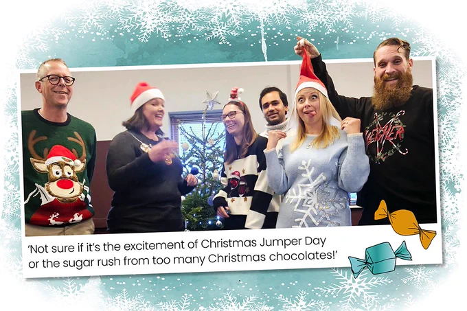 The  office team in their Christmas jumpers in front of the tree making silly faces