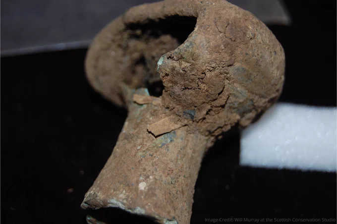 A broken, bronze spearbutt in the shape of a doorknob 