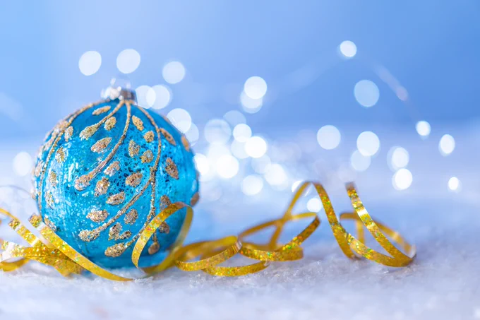 An image of a blue Christmas bauble with a gold ribbon