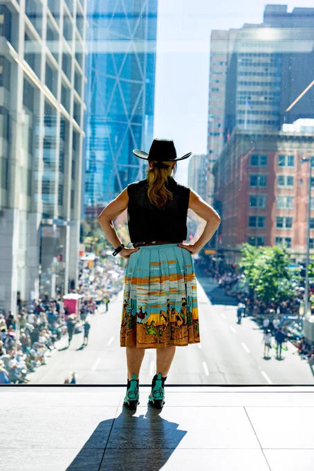 Rachel Notley with her hands on her hips looking out over Calgary