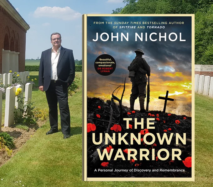 John in a WW1 cemetery with an image of his book next to him