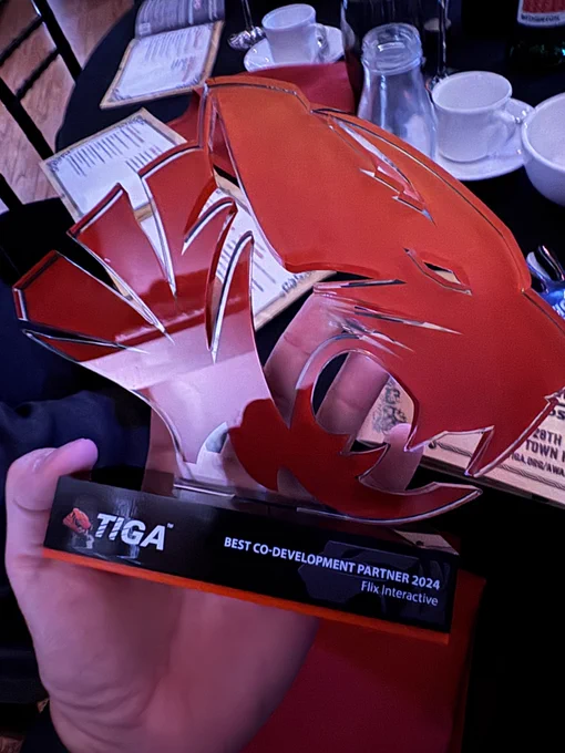 A trophy in the shape of a tiger's head, the logo of TIGA. The trophy says "Best Co-Development Partner 2024"