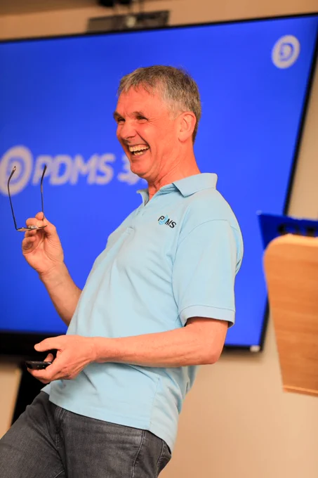 A photo of Chris Gledhill in front of a screen laughing