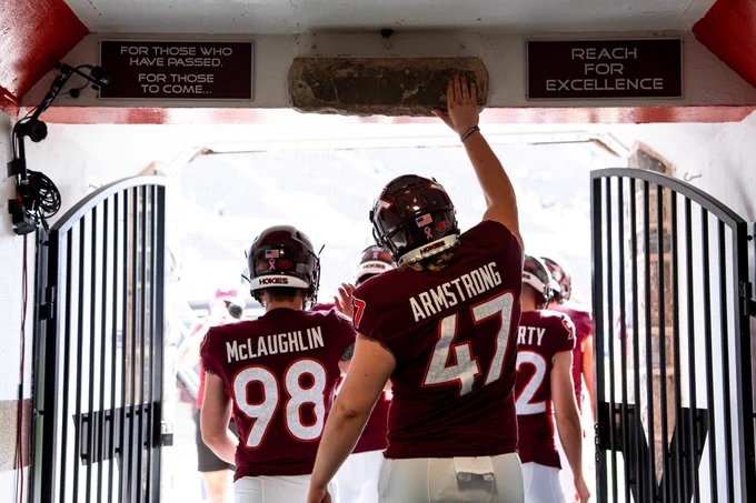 Griffin Armstrong reaches up to touch the Hokie Stone above the tunnel walking onto Worsham Field