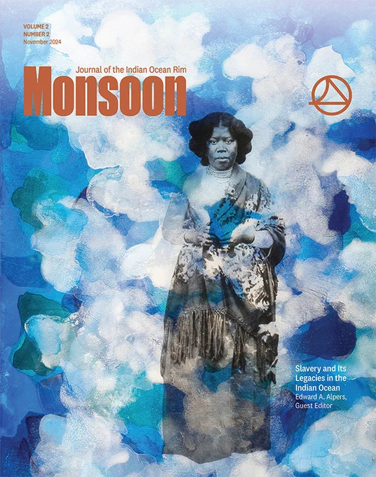 Cover of Monsoon volume 2 issue 2. Features a painted blue and white background. A black and white image of a person wearing a dress and floral pattered shawl is centered. The journal's name is printed in dark orange text. The title of the issue and the editor's name appear in white text.