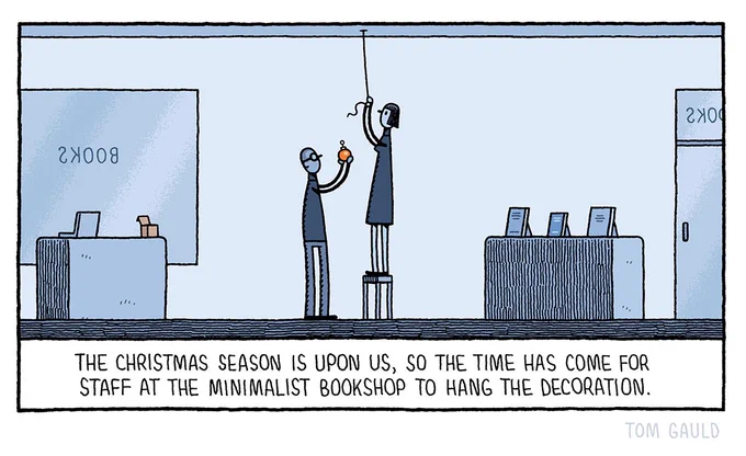 Image: A stylishly restrained bookshop with only a few books on display. Two cool people are hanging a red bauble.

Caption: The Christmas season is upon us, so the time has come for staff at the minimalist bookshop to hang the decoration.