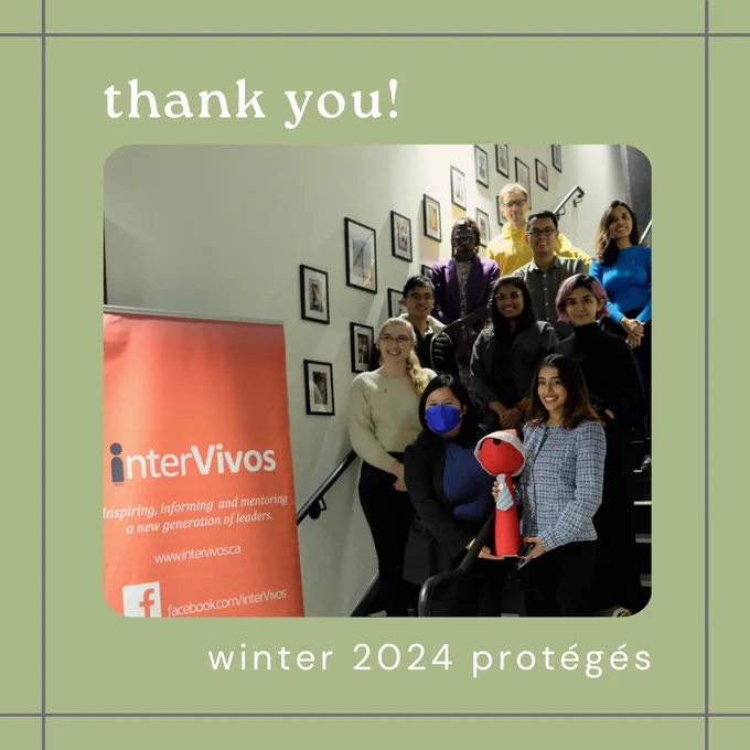 Ten protégés with Peg the mascot in a Santa hat, standing on stairs beside the interVivos sign. 