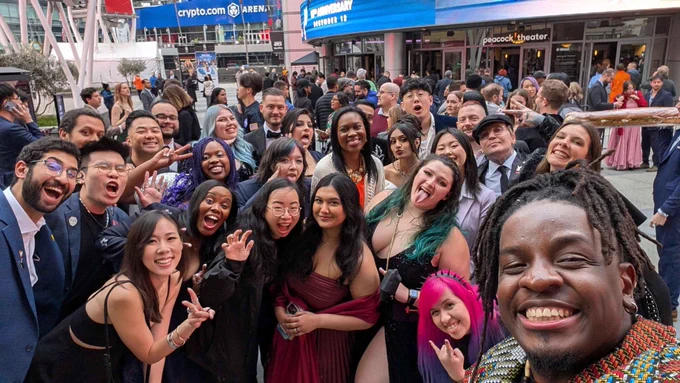 A Renaissance level group photo of 20ish people who are members of the game awards future class. Everyone is smiling or waving or yelling or doing peace signs. It's chaotic and joyful 