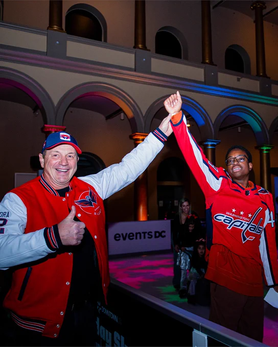 Peter Bondra poses for a photo with a Capitals fan skating at the National Building Museum.