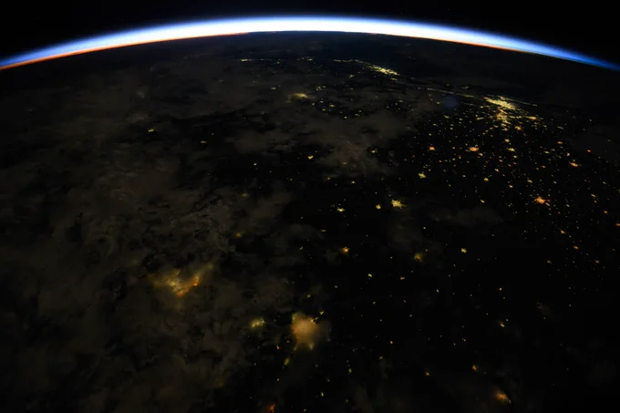 An orbital sunrise crowns Earth's horizon in this photograph from the International Space Station as it orbited 261 miles above Brazil. At top right, the city lights of Rio de Janiero and Sao Paulo on the Atlantic coast are visible from the orbital outpost.