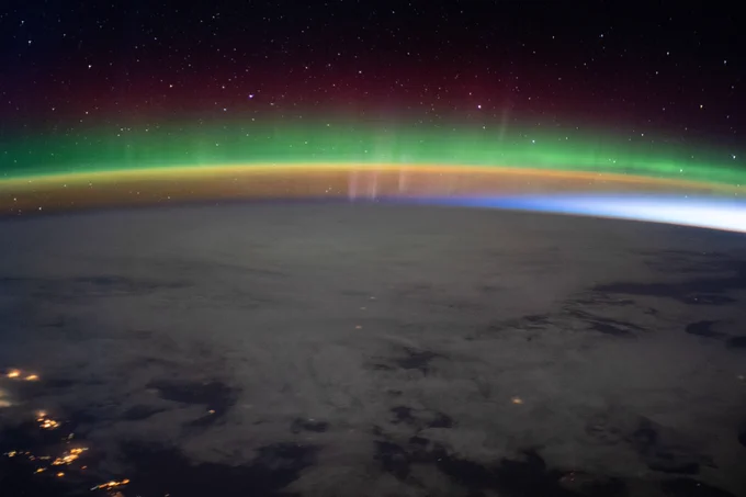 A bright aurora crowns Earth's horizon beneath a starry sky as the International Space Station flew into an orbital sunrise 264 miles above north Montana in the United States.