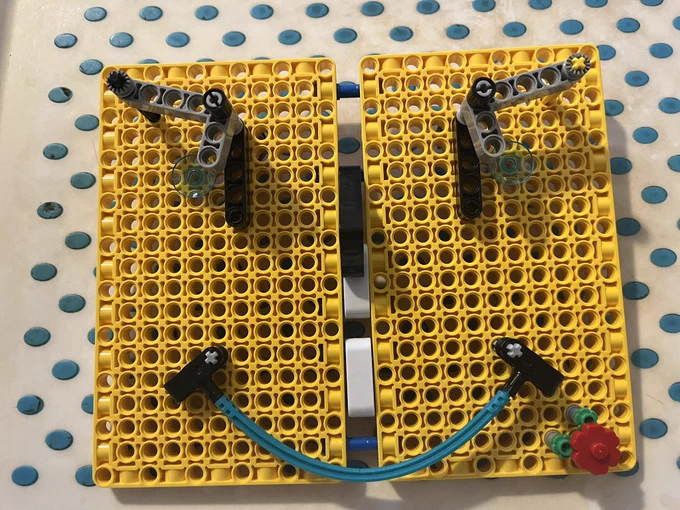 Face made out of yellow lego panels, grey eyebrows & bendy mouth