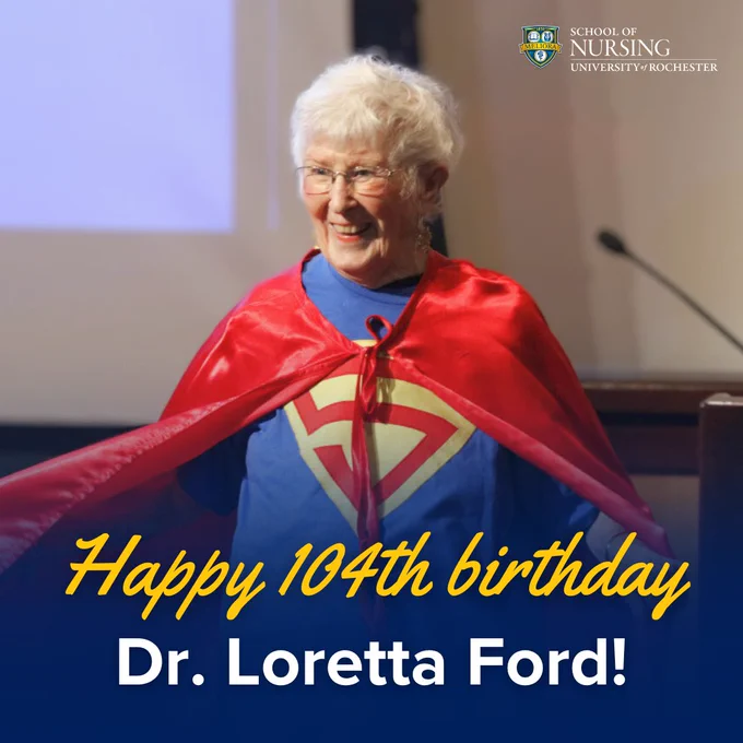 Photo of Loretta Ford smiling at a 2017 event, wearing blue Superman t-shirt and red cape. Text under the photo reads: Happy 104th birthday, Dr. Loretta Ford! 