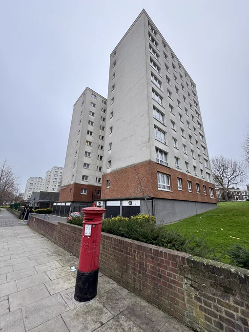 Red postbox with 1960s flats
