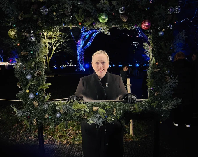 Rebecca Evans in a festive wreath frame at Bute Park | Rebecca Evans mewn ffram torch Nadolig ym Mharc Bute