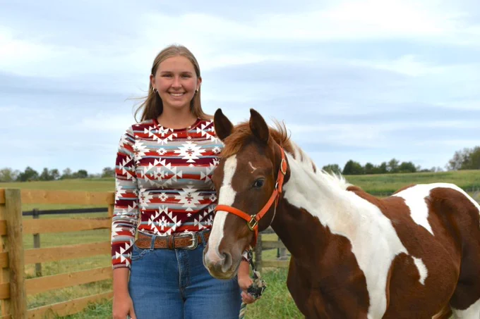 Ashtyn stands with a young horse