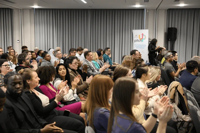 A room is filled with an audience as they applaud at Venturefest West Midlands 2024.