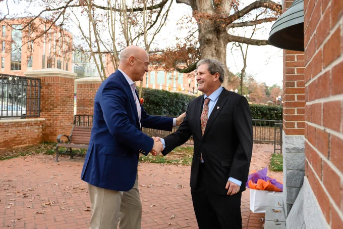 President Clements and Dr. Robert Baldwin posing shaking hands in the Carillon Garden.