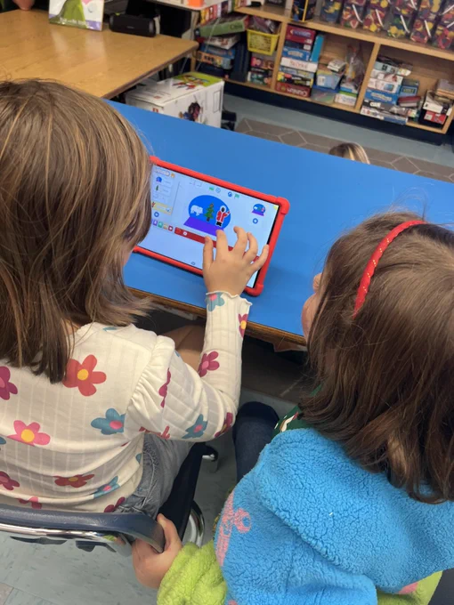 Two girls work together to code a snow globe