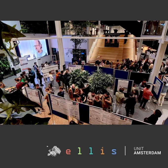 Attendees gather and interact at a busy networking event hosted by ELLIS Unit Amsterdam, with posters displayed and a presentation visible on a screen in the background.