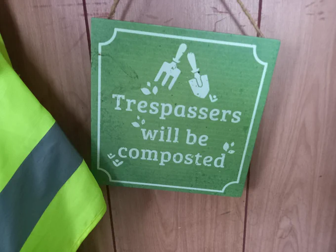 Trespassers will be composted sign with yellow safety jacket