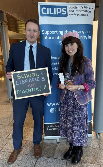 Kirsten with Fulton MacGregor MSP and a blackboard Reading ‘School Libraries are Essential!’