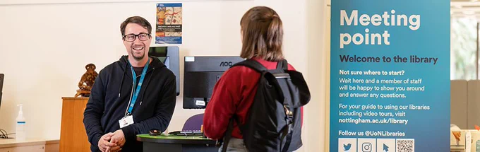 Library staff talking to a student