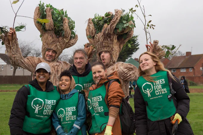 Trees for Cities volunteers pose with the Roaming Trees at a planting event