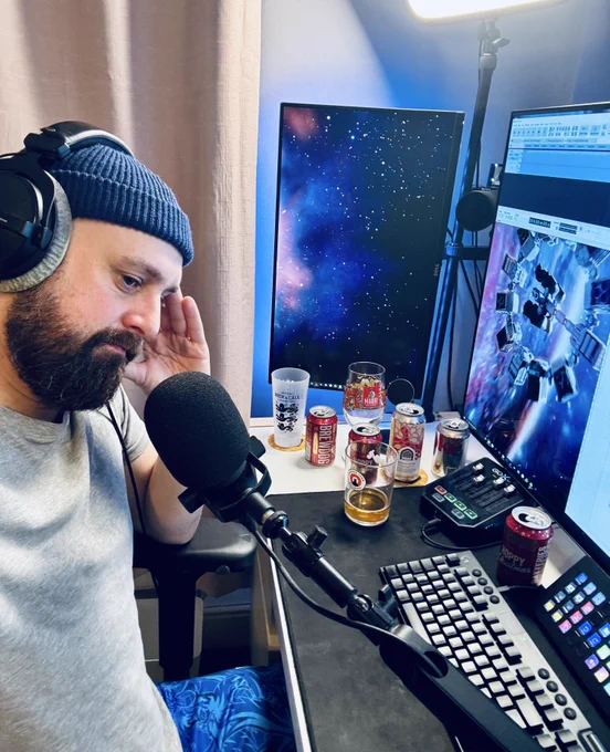 Man showing zero emotion sitting at his desk with beer cans in the background after recording a four and a half hour Game of the Year podcast.