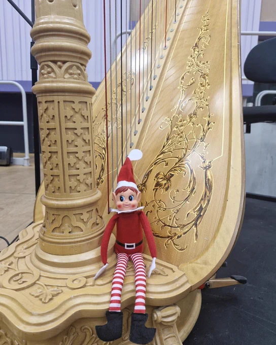 A toy elf sat on a harp