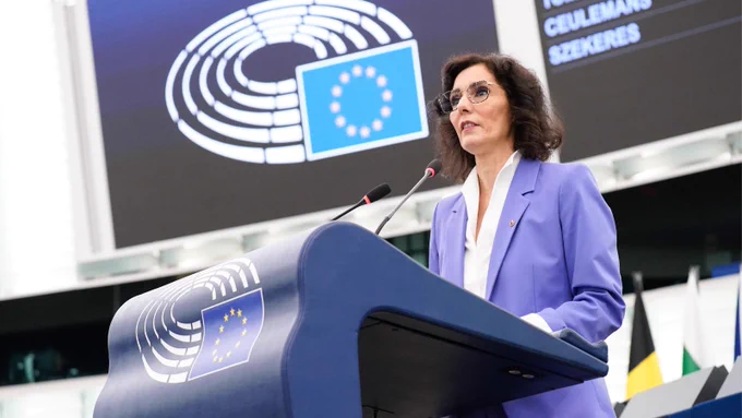 Commissioner Lahbib speaks at a podium. The podium is blue with the logo of the European Parliament.