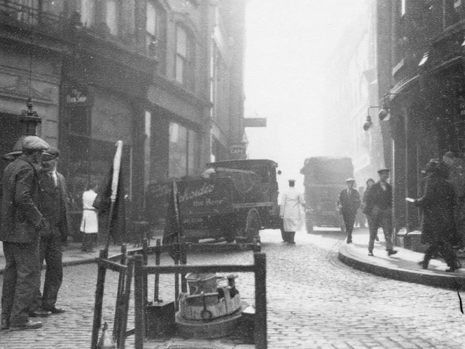  Roadworks, men in flat caps and 1920s Trucks in the cobbled Saddler Street / Market Place, Durham 