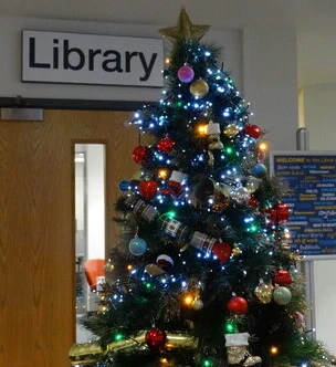 A decorated Christmas tree outside the entrance of Swindon Library