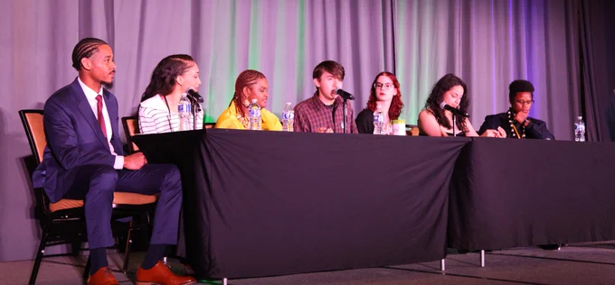 Seven youth panelists seated at a long table on stage at the National Grantee Training.