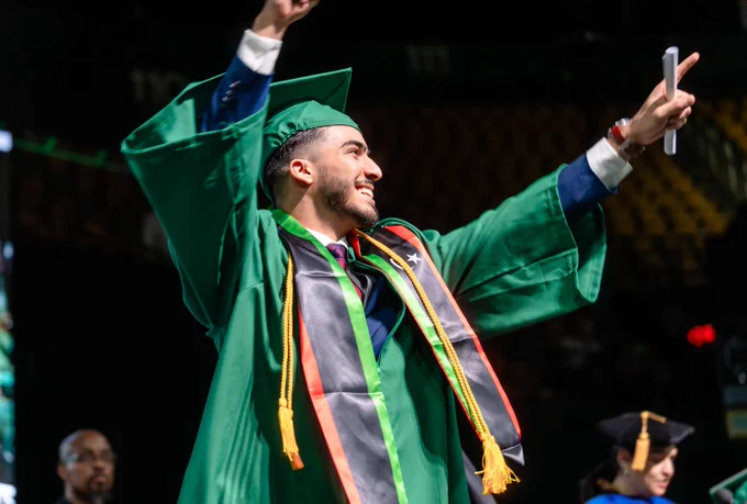 Student walks the stage at George Mason University's 2024 Winter graduation.