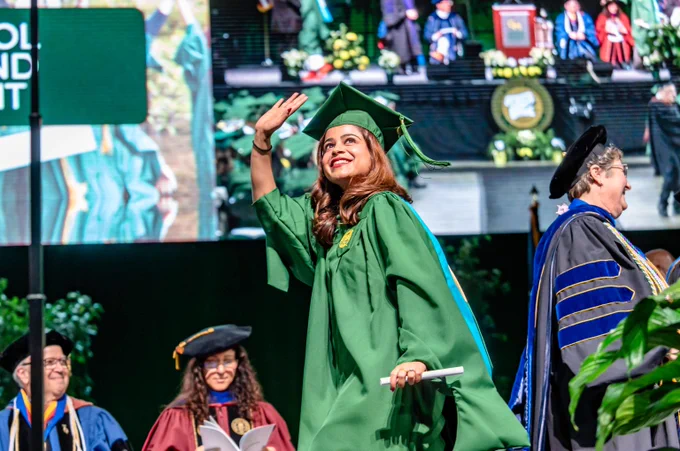 Student walks the stage at George Mason University's 2024 Winter graduation.