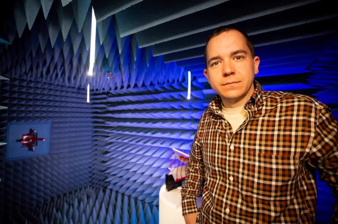 A man, Jonathan Lundquist, looking directly at the camera with a confident expression, standing against a blue background.
