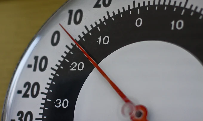 A black and white thermometer with a red needle pointing towards 4 degrees Fahrenheit.
