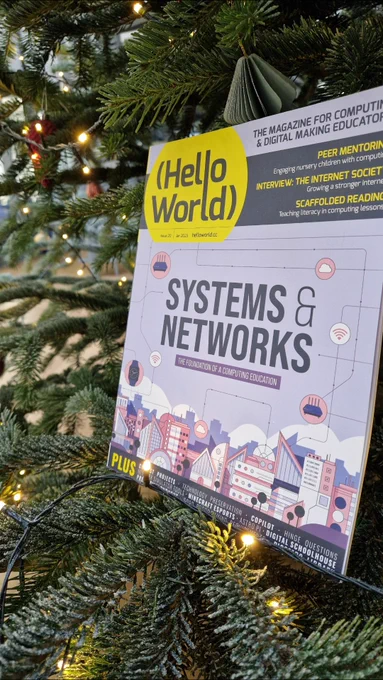 Photo of a physical copy of Hello World, Issue 20, ' Systems & Networks', displayed in a Christmas tree, amongst the branches.