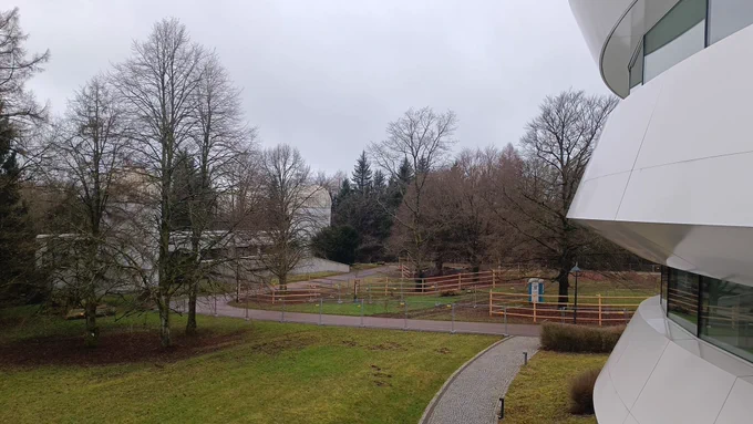 Blick vom HdA-Südbalkon auf  das Elsässerlabor mit zei Teleskopkuppeln, auf der Rasenfläche dazwischen sind mehrere Holz-Lattenzäune und ein Bauzaun errichtet
