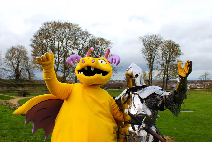 Ilbert the Dragon and a knight in shining armour both waving an arm in the air at Pontefract Castle