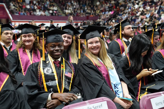 CALS graduating students in caps and gowns await the commencement ceremony
