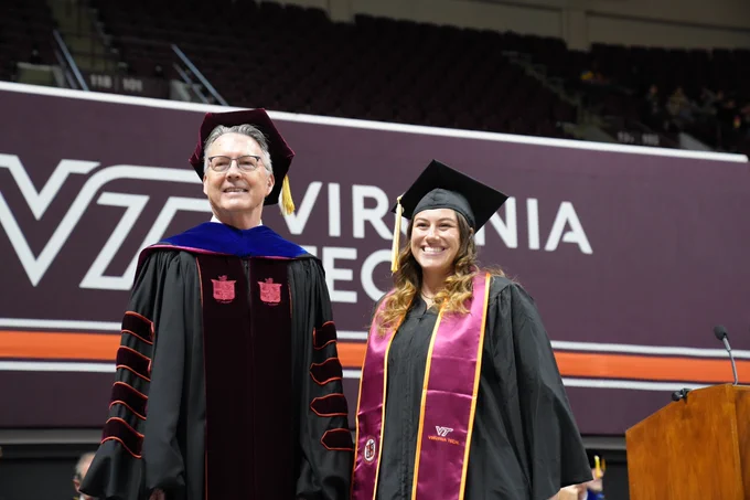 A graduating CALS student poses with Virginia Tech president Tim Sands