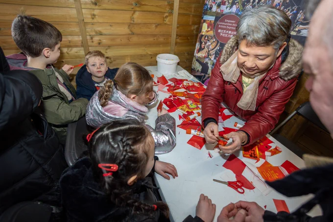 An overhead image of children interacting with an arts and craft stall during Lunar New Year celebrations.