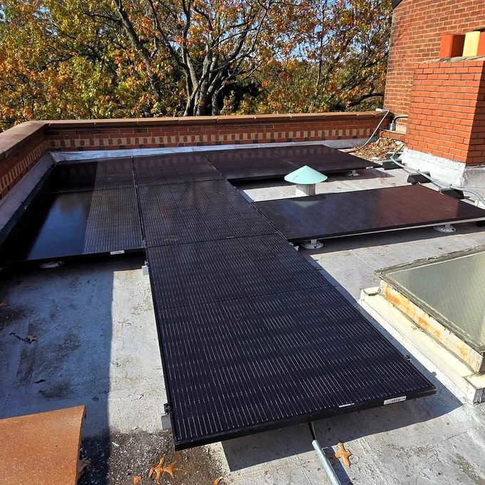 Solar panels on a flat roof surrounded by intricate brickwork.