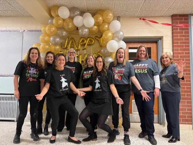 A group of St. Mary Catholic School staff wearing Happy Birthday Jesus shirts.