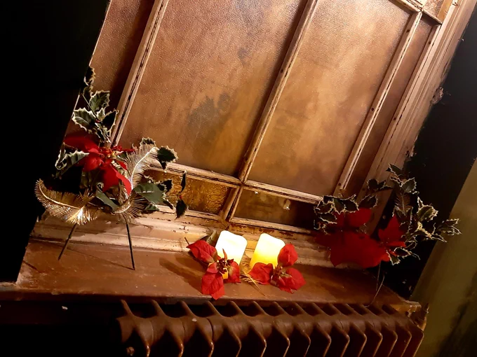 Window ledge decorated with holly and candles 