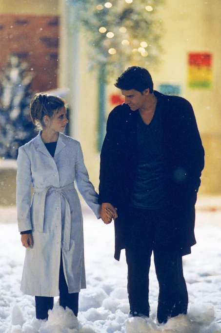 Buffy and Angel walk hand in hand in the Sunnydale snow